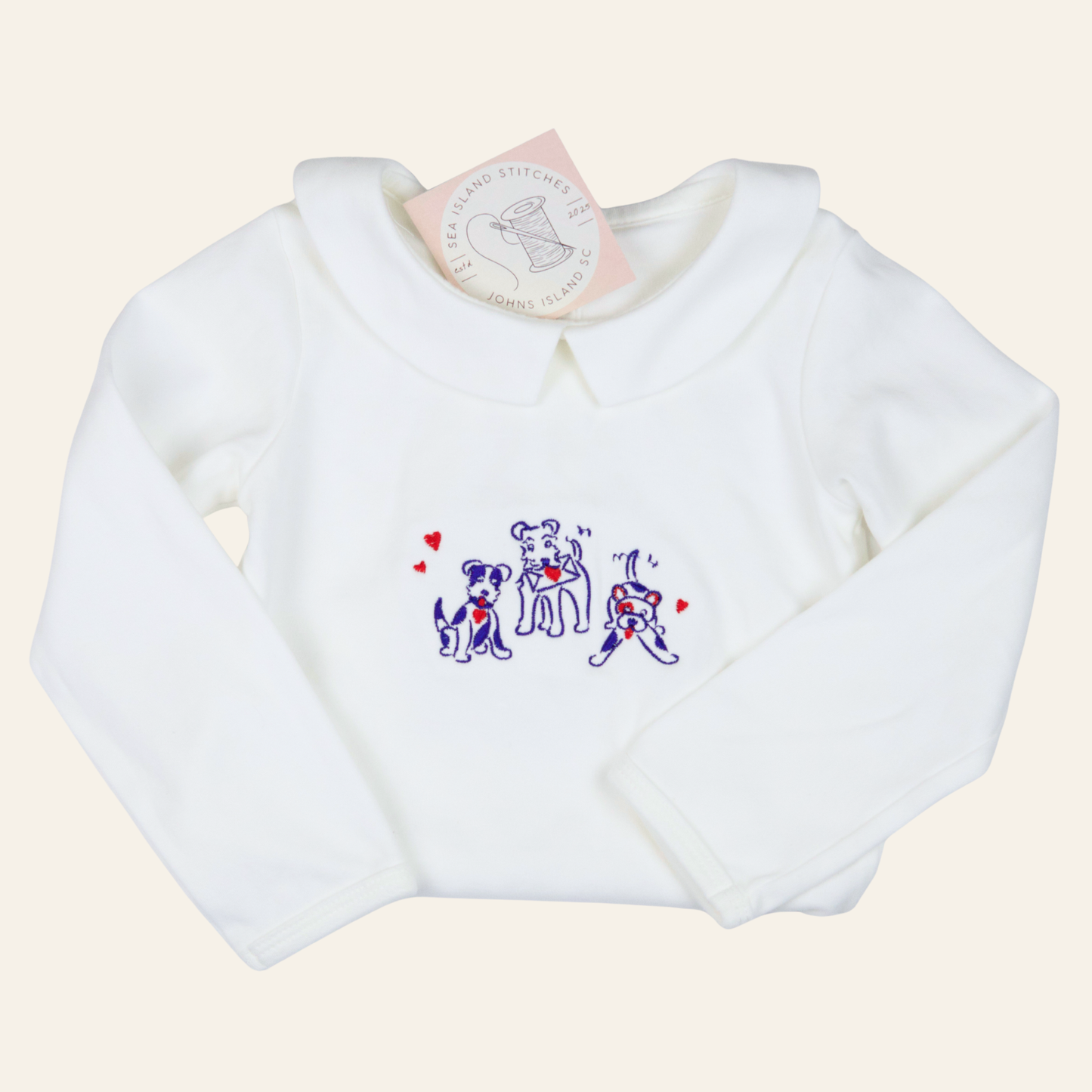 White baby sweatshirt featuring embroidered puppies and red hearts with a classic Peter Pan collar. Soft, sweet, and perfect for everyday or special occasions.