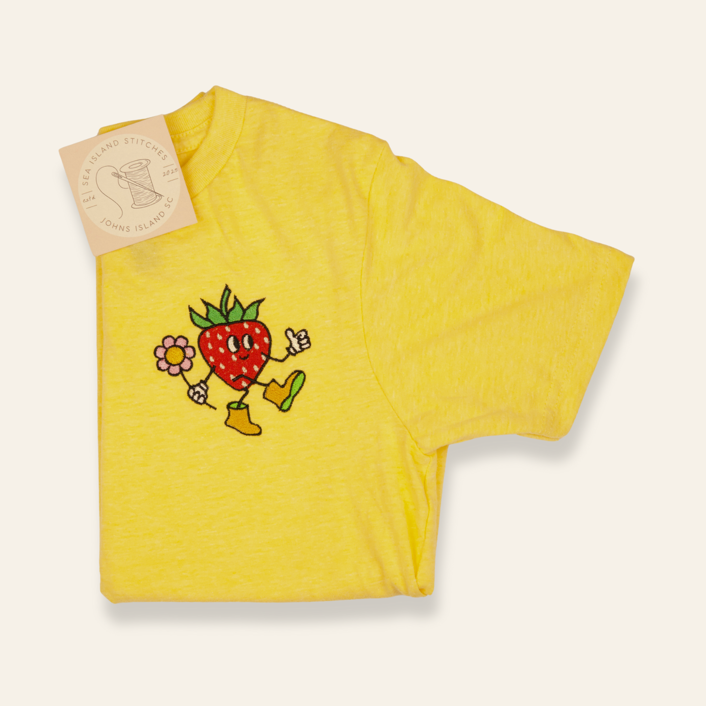 Yellow kids t-shirt featuring an embroidered strawberry character with a flower. Playful, cheerful, and perfect for everyday wear.