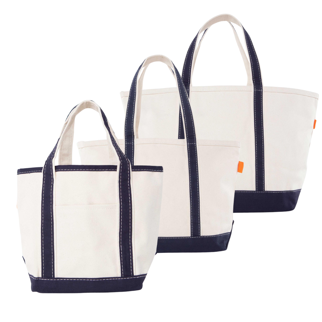 Three white tote bags with navy accents on a white background.