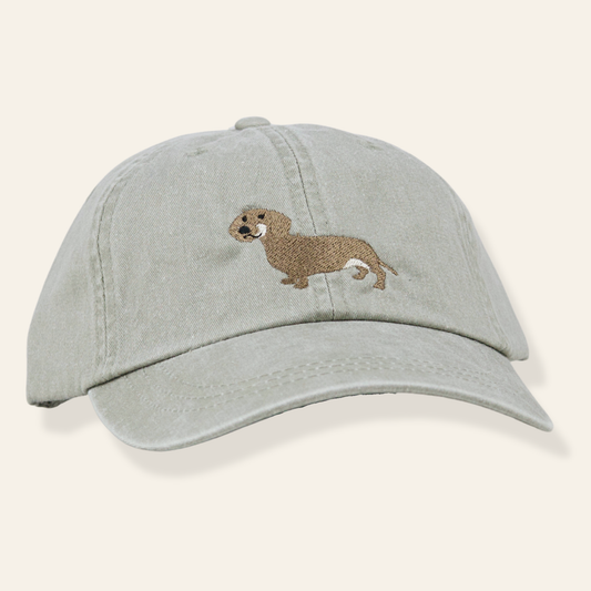Washed sage embroidered cap featuring a dachshund design. Soft cotton, adjustable fit, and perfect for everyday wear or gifting.