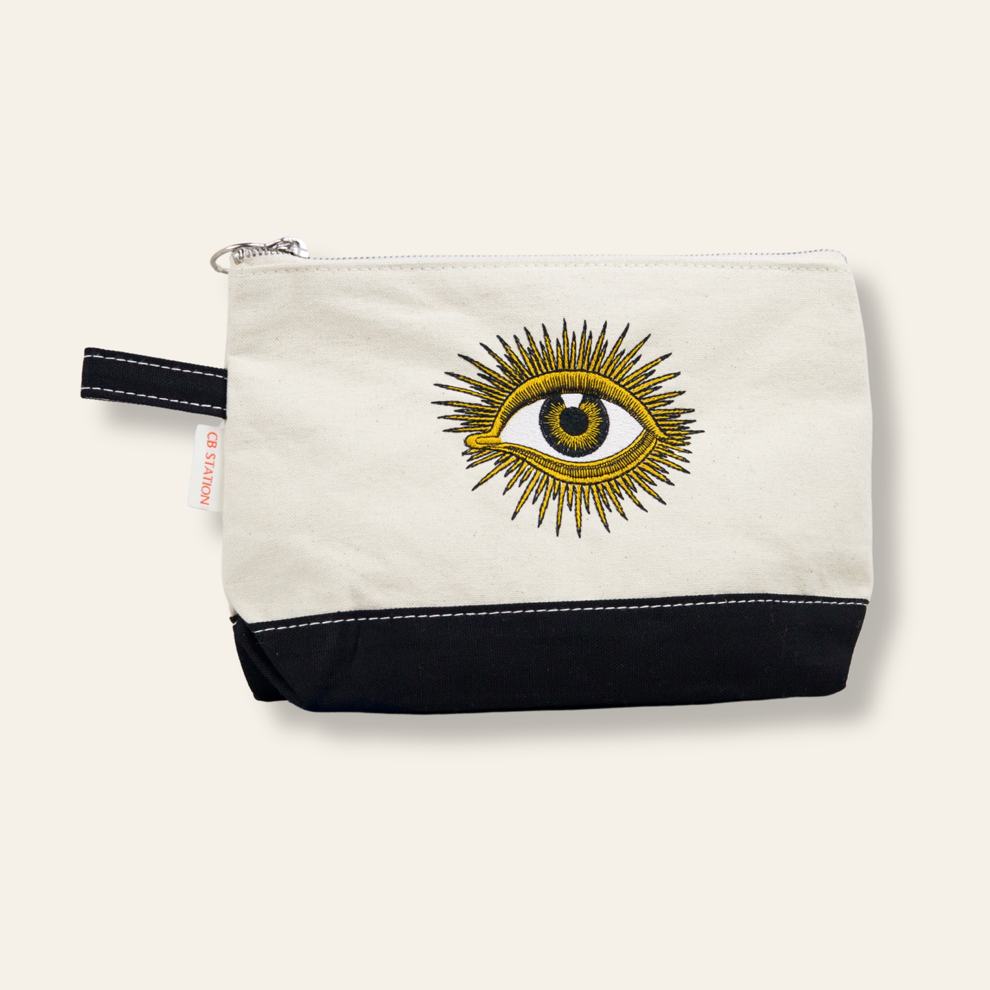 A canvas zipper pouch featuring an embroidered evil eye symbol for protection and good energy. Functional, meaningful, and giftable.