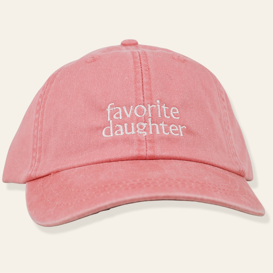 Washed pink embroidered cap featuring “favorite daughter.” Soft cotton, adjustable fit, and perfect for everyday wear or gifting.