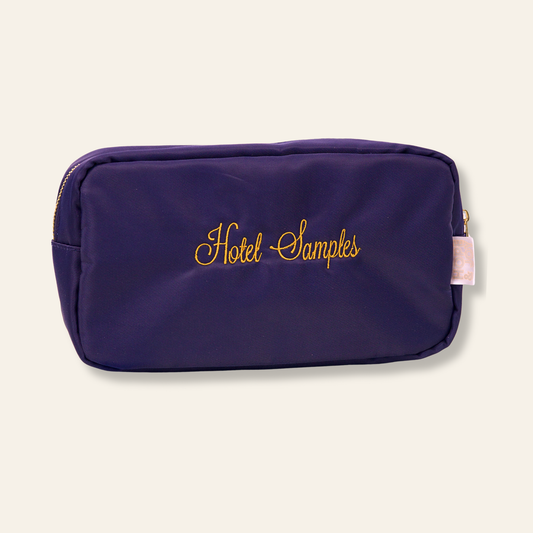 A navy embroidered pouch that says “Hotel Samples.” Perfect for travel toiletries, skincare, and anyone who loves a good inside joke