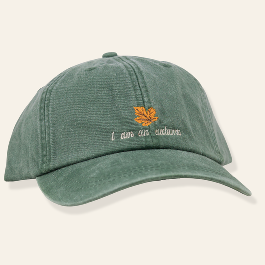 Washed green embroidered cap featuring “i am an autumn” with a leaf design. Soft cotton, adjustable fit, and perfect for everyday wear.