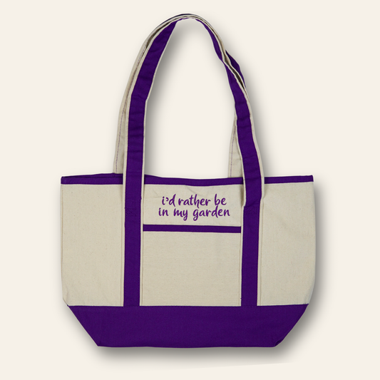 Embroidered canvas tote with purple trim and the phrase “I’d rather be in my garden.” A reusable everyday bag perfect for gardeners and plant lovers.